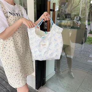 Detail of cartoon bear canvas tote with dual-tone woven handles and snap button closure