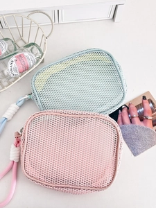 Detail of mesh makeup bags in mint green and pink with rope handles and zippers