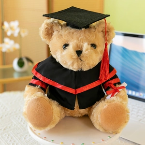 Cute plush graduation teddy bear wearing black gown and mortarboard with red tassel
