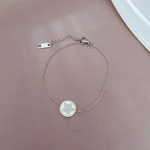 Detailed macro view of silver stainless steel chain bracelet with star pendant