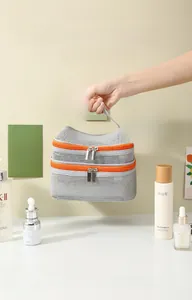 Close-up of a double-layered mesh travel bag with bright orange zippers and top handle
