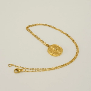 Macro detail of gold stainless steel necklace with sunburst starburst diamond pendant
