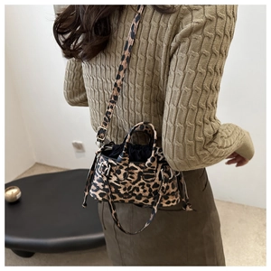 Dettaglio della borsa leopardata con fodera nera a coulisse e finiture in metallo
