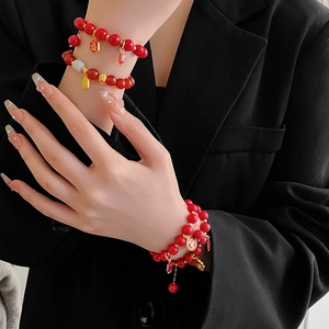 Gros plan d'un bracelet de perles rouges du Nouvel An chinois avec des pendentifs Fu