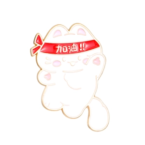 Detail of white enamel cat brooch with red headband featuring Jiayou text