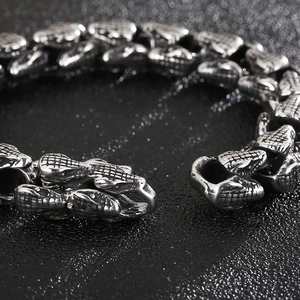 Dettaglio macro del bracciale punk in acciaio inossidabile con texture a scaglie di serpente