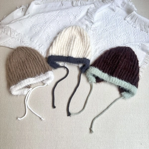 Three plush knitted earflap hats for kids in brown and beige with stylish contrast ties