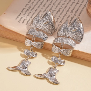 Detailed view of silver fishbone earrings on a vintage book page backdrop