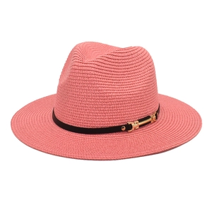 Detailed view of pink straw fedora hat with black leather band and gold buckle