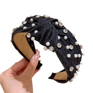 Denim blue knotted headband with sparkling rhinestones and white pearls on white background