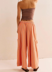 Rear view of striped wide leg cargo pants featuring vibrant orange and purple vertical lines