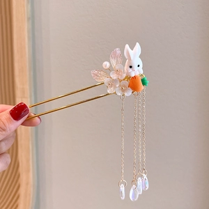 Detail of golden hair stick with rabbit, carrot charms, flowers, and pearl tassels