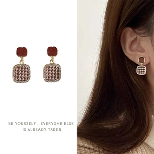 French vintage geometric houndstooth and red square stud earrings on model and white backdrop