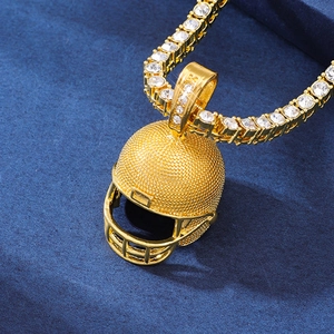 Detailed view of a golden American football helmet pendant on a sparkly tennis chain
