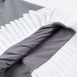 Detail of dark grey fabric with white pleated hem stitching on a sleeveless dress