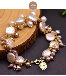 Detail showing natural baroque pearls and a gold religious coin pendant on a beaded bracelet