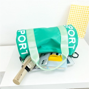 Detail showing the large capacity interior of a green nylon kids sport crossbody bag