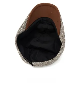 Detail of the internal lining and stitching of a tweed newsboy cap for men