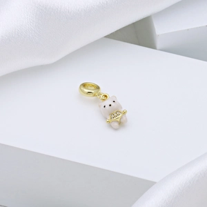 Cute bear charm pendant with gold plating and white enamel on minimalist satin background
