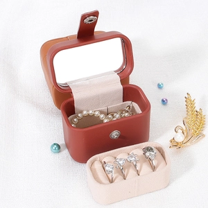 Portable brown leather jewelry box with mirror and soft beige velvet lining for travel