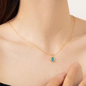 Elegant 18K gold S925 silver necklace with blue teardrop zircon pendant on a model