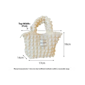 Detailed view of white bubble texture canvas bag with logo tag and size specifications