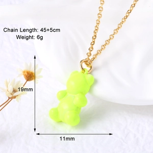 Detail view of neon green gummy bear pendant with golden necklace and size labels