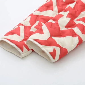 Détail des poignets matelassés avec motif d'étoiles rouges et blanches et tissu coupe-vent