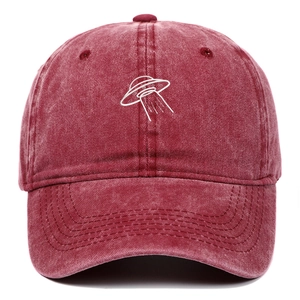 Detailed close-up of white UFO embroidery on a washed burgundy vintage baseball cap