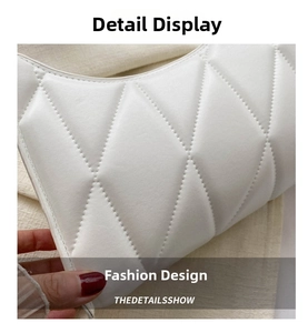 Close-up of white quilted leather texture and neat stitching on a square shoulder bag