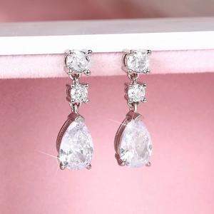 Macro shot of silver teardrop earrings featuring sparkling micro-pave pear-cut zircons