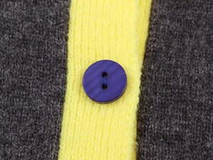 Macro shot of contrasting knit fabric with a purple striped button detail