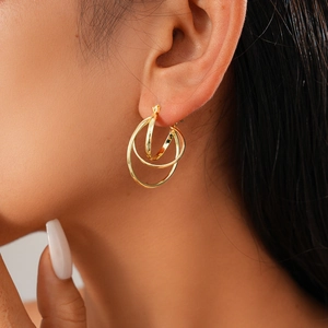 Close-up of elegant double gold hoop geometric earrings on model for a trendy look