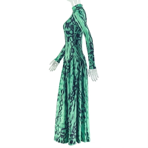 Detail view of the pleated long sleeve dress featuring abstract green and black prints