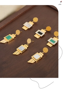Detail of six vintage geometric gold earrings with shell, enamel and zircon inlays