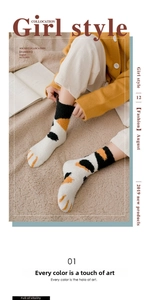 Detailed view of thick coral fleece socks featuring cute calico cat paw patterns