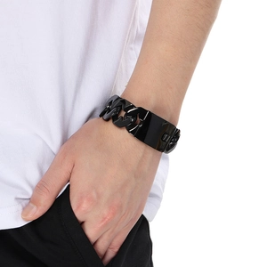Close-up of chunky black stainless steel Cuban link bracelet with spike elements on wrist