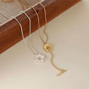 Detail view of gold and silver flower toggle necklaces with elegant round bead chains