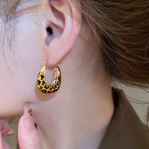 Close-up of vintage leopard print square pendant hoop earring on a model's ear