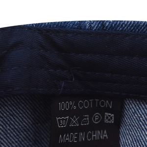 Close-up of internal cotton tag and woven texture on washed denim baseball cap