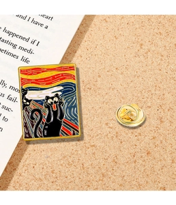 Macro detail of enamel brooch featuring a screaming black cat inspired by The Scream painting