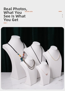 Detailed view of white portrait necklace display stands in five various heights