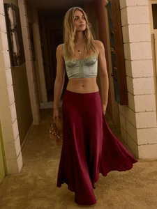 Detail of elegant wine red satin midi skirt with lace stitching and silky texture