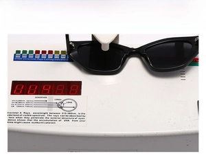 Detail of UV400 test on black cat-eye sunglasses showing UV-A/B/C protection level