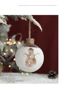 Detail of a transparent Christmas glass ball featuring a snowman and artificial snow inside