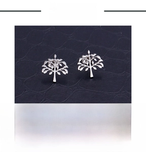Macro shot of stainless steel tree of life stud earrings showing hollow cut design