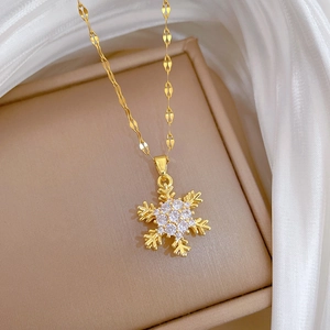Detailed view of a gold snowflake necklace with white zircons on premium silk