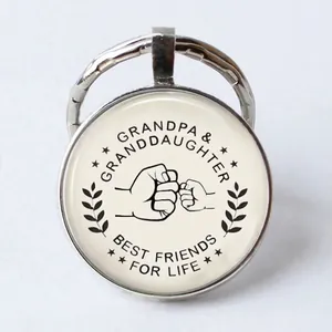 Macro detail of silver alloy keychain with Grandpa and Granddaughter fist bump art