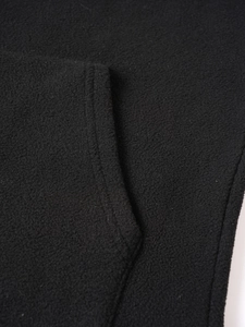 Detail shot of black fleece fabric texture and durable pocket stitching on sweatshirt