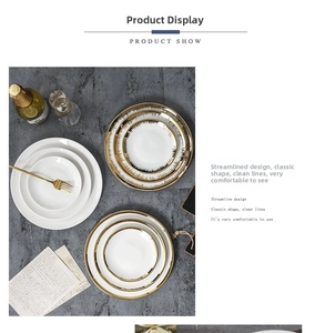 Flat lay of Nordic ceramic dinner plates with gold rims and stainless steel forks